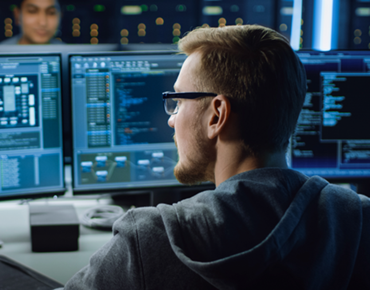 Developer looking on computer screens full of code